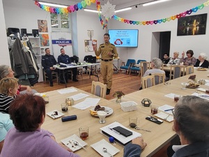 strażak stoi na srodku sali i prowadzi prelekcję
