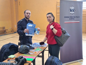 Policjant przekazuje ulotki dotyczące akcji "Kręci mnie bezpieczeństwo w zimie"