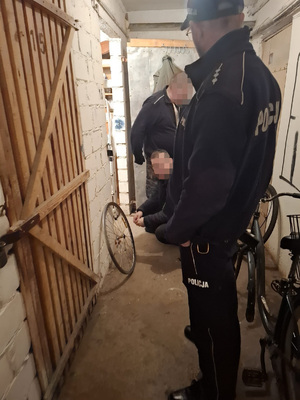 policjant stojący w korytarzu piwnicy