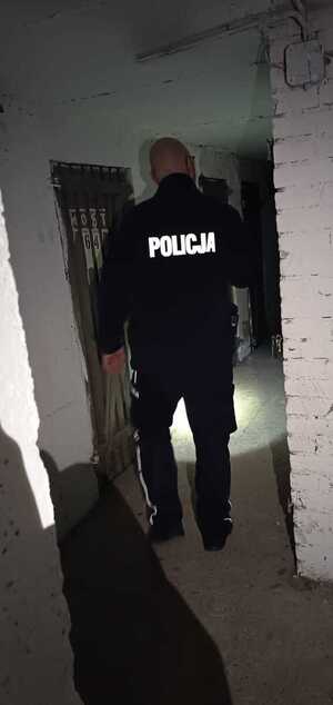 policjant stojący w korytarzu piwnicy