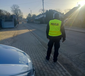 policjant stojący na drodze  kontrolujący samochody