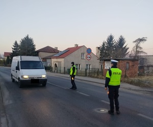 dwóch policjantów na drodze zatrzymauje samochód