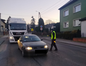 policjant podchodzi do pojazdu na drodze