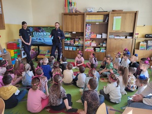 dwoch policjantów stoi przed dziećmi