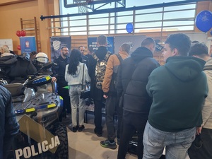 grupa osób stoja przy policyjnym stanowisko, obok stoi Quad w policyjnych barwach