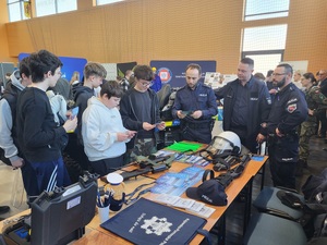 policyjne stanowisko przy którym stoja policjanci i uczestnicy wydarzenia