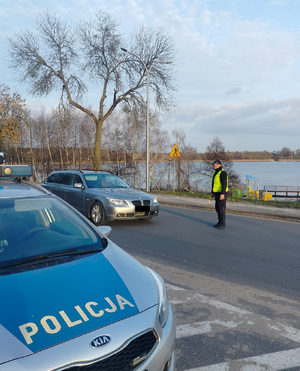 policjant na drodze podchodzi do zatrzymanego pojazdu