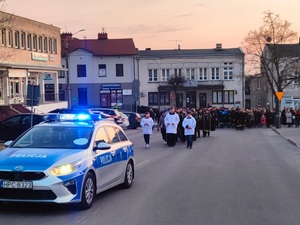 policyjne radiowozy stoja na drodze i zabezpieczają przejście pątników