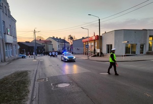 policyjne radiowozy stoja na drodze i zabezpieczają przejście pątników