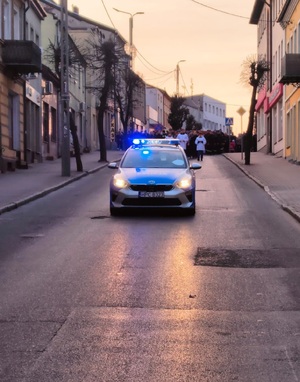 policyjne radiowozy jedzie przed idącymi pątnikami