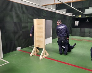 jeden policjant ewakuuje drugiego policjanta przesuwając go za osłonę