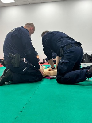 dwóch policjantów wykonują uciski na fantomie