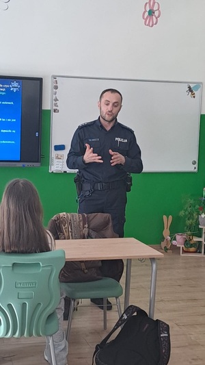 policjant stojący przed uczniami w klasie