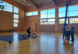 jeden z zawodników pokonuje tor przeszków, trzy osoby z komisji obserwują wykonanie zadania