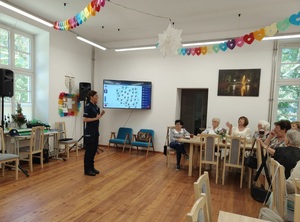 policjantka stoi przed uczestnikami spotkania