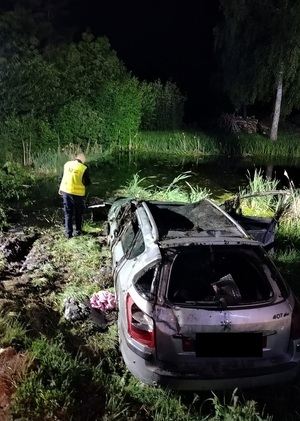 policjant stojący przy wyciagnietym samochodzie