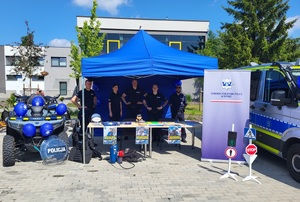 czterech policjantów stojacych przy policyjnym stanowisku, obok stoi radiowóz oraz quad