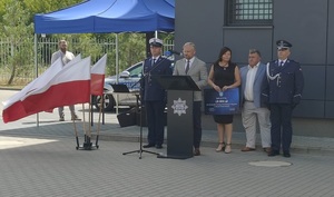 zaproszeni goście stoja przed mównica