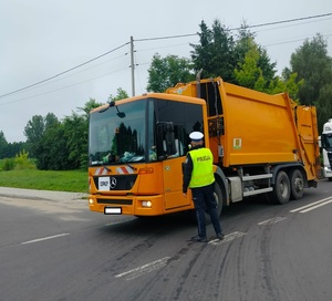 policjant stoi policjant stoi przy pojeździe i bada stan trzexwości kierowcy