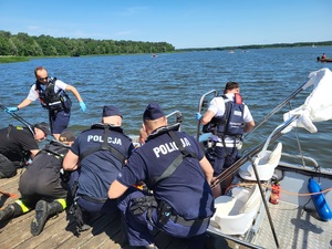 policjanci podejmuja z łodzi poszkodowanych