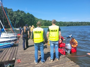 policjanci stoja na pomoście gdzie przywożeni sa poszkodowani