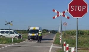 policjant wskazuje miejsce do zatrzymania pojazdu przed przejazdem kolejowym