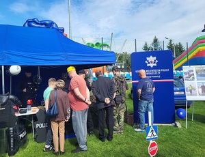 kilka osob stojąca przy policyjnym stanowisku