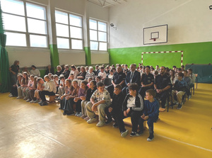 zdjecie wszystkich zebranych na uroczystosci siedzacych na łąwkach