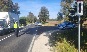 policjant na drodze kieruje ruchem, na droge wyjeżdzają radiowozy
