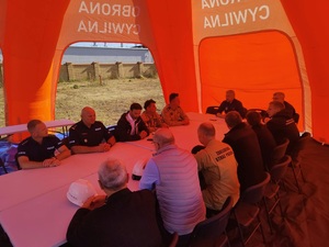 podsumowanie działań, przedstawiciele słuzb siedza przy stole