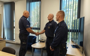 trzech policjantów, komendat podaje reki jubilatowi